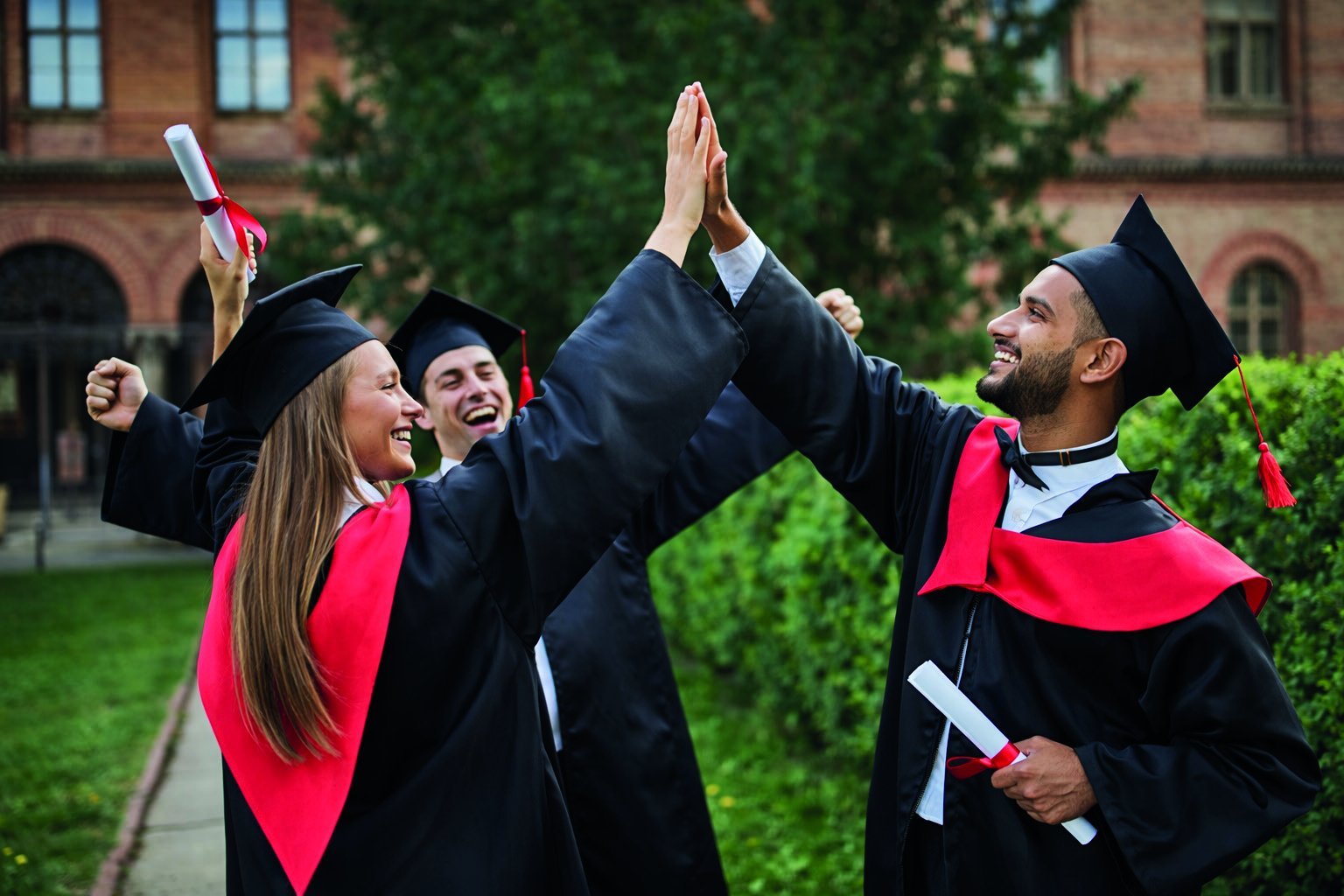 Graduating students celebrating with a high-five