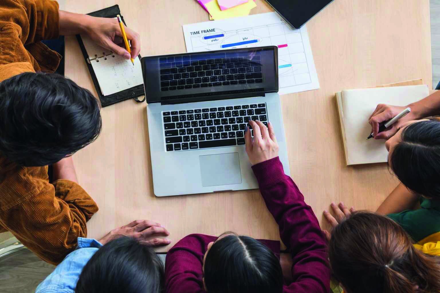 Team planning career roadmap together around a laptop
